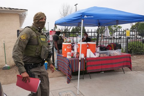 A woman is detained by U.S. Border Patrol agents outside a Home Depot Friday, Aug. 15, 2025, in Los Angeles. (AP Photo/Gregory Bull)